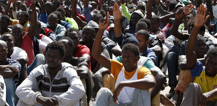 Illegal migrants sit at a temporary detention centre after they were detained by Libyan authorities