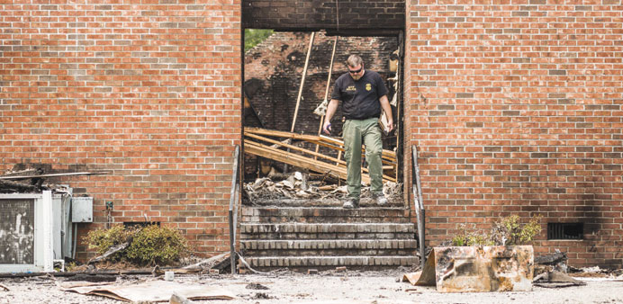 An ATF investigator walks through the burned ruins of the Mt Zion AME Church on Wednesday.