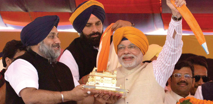 Gujaratu2019s Chief Minister Narendra Modi is presented with a sword and a memento by Punjab deputy Chief Minister Sukhbir Singh Badal during a rally at J