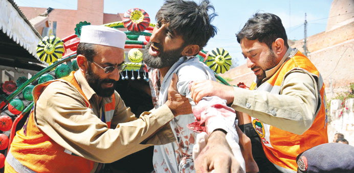 Pakistani rescue workers carry a victim who was injured in a bomb blast targeting a camp for internally displaced people, to a local hospital in Pesha