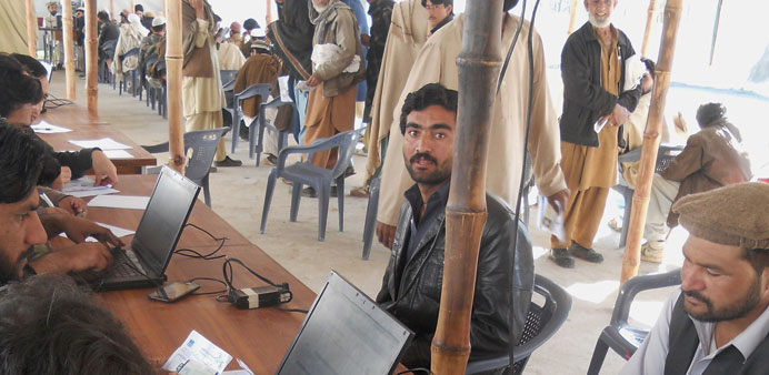 Internally displaced Pakistani tribesmen get their identities verified at the UNHCR food supply camp in Kohat.