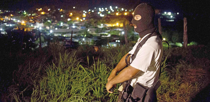 A member of the Citizensu2019 Self-Protection Police stand guard in Aguililla, Michoacan state. Citizens have resorted to forming or hiring people to prot