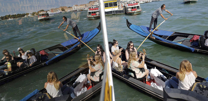 Tourists sit in a gondola yesterday in Venice. The Venice Film Festival starts on Wednesday.
