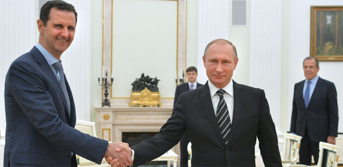 Russian President Vladimir Putin (R) shakes hands with his Syrian counterpart Bashar al-Assad (L) 