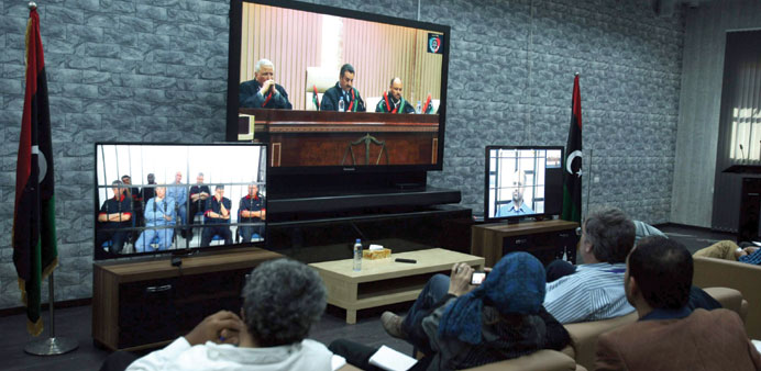 Journalists watch screens broadcasting the trial of Saif al-Islam Gaddafi (screen on right) and former officials in Tripoli yesterday.