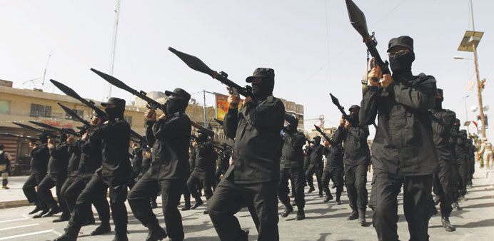 Fighters loyal to Shia cleric Moqtada al-Sadr parade in Baghdadu2019s Sadr City yesterday.