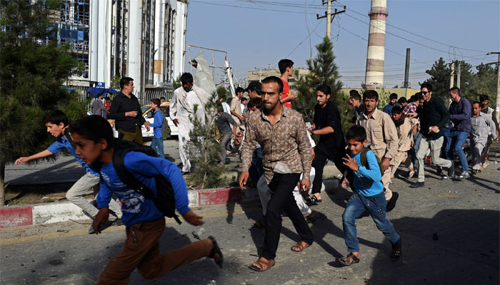 Afghan schoolboys and residents run at the site of a car bomb in Kabul. AFP