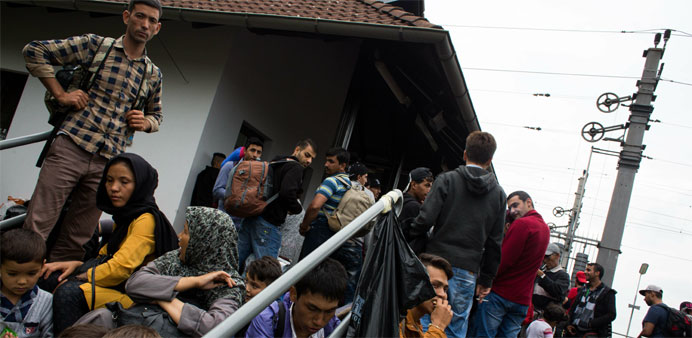 Migrants wait to board a train to Vienna at the railway station in Nickelsdorf 