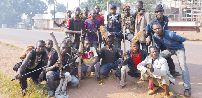 Anti-Balaka militiamen pose in a street of the Gobongo neighborhood in Bangui yesterday. Right:  French soldiers in Bangui yesterday.