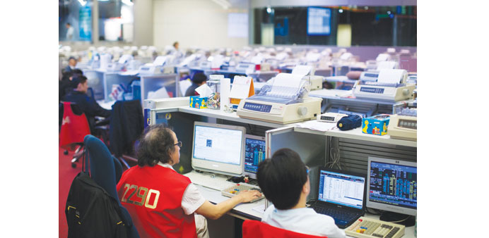 Traders work at the Hong Kong Stock Exchange. Shares closed down 485.09 points to 24,705.36 yesterday.