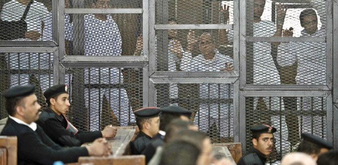 Australian journalist Peter Greste of Al Jazeera and his colleagues stand inside the defendantsu2019 cage during their trial at Cairou2019s Tora prison yester