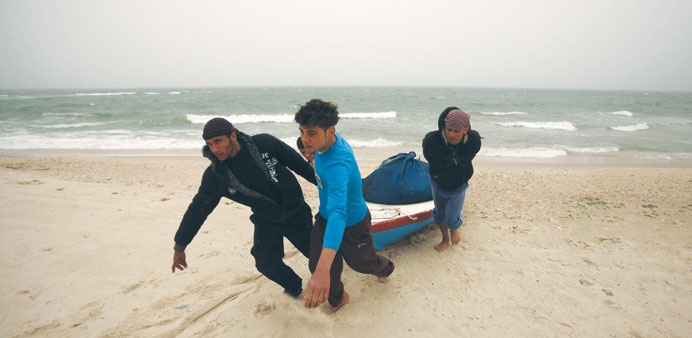 Palestinian fishermen pull their boat on a beach in Gaza City. Israel has enforced a newly restricted 5km-wide fishing zone.