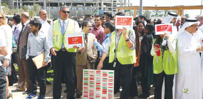 Commercialbank staff gather at a safe assembly point during a mock evacuation drill yesterday.