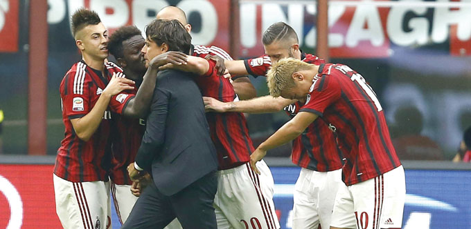 AC Milanu2019s Sulley Muntari (2nd left) celebrates with coach Filippo Inzaghi and teammates after scoring against Lazio during their Italian Serie A matc