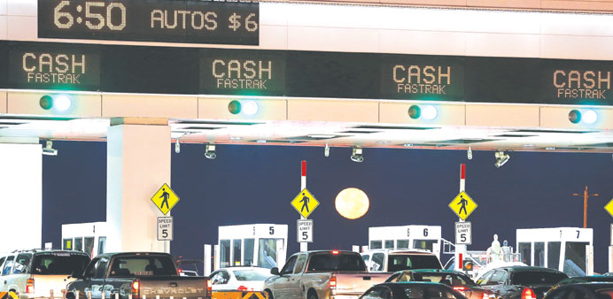    The moon sets as traffic backs up at the San Francisco-Oakland Bay Bridge toll plaza while commuters make their way into San Francisco on the first
