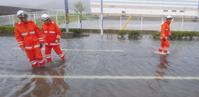 Rescue personnel investigate minor flooding as strong winds and heavy rains from Typhoon Halong hit the resort town of Tonosho on Shodoshima island, K