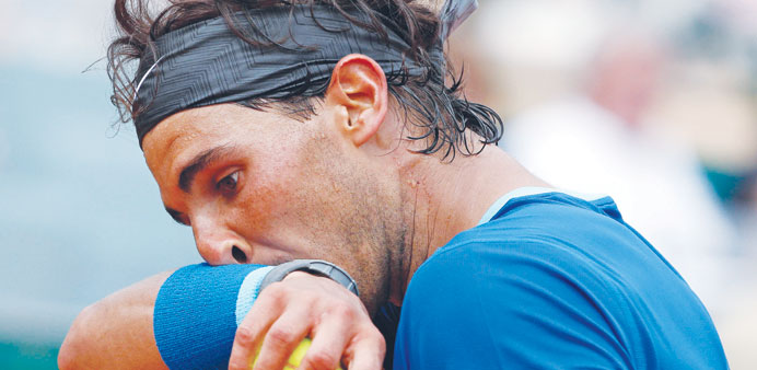 Rafael Nadal of Spain wipes his face during his quarter-final match against his compatriot David Ferrer (below) at the Monte Carlo Masters in Monaco y