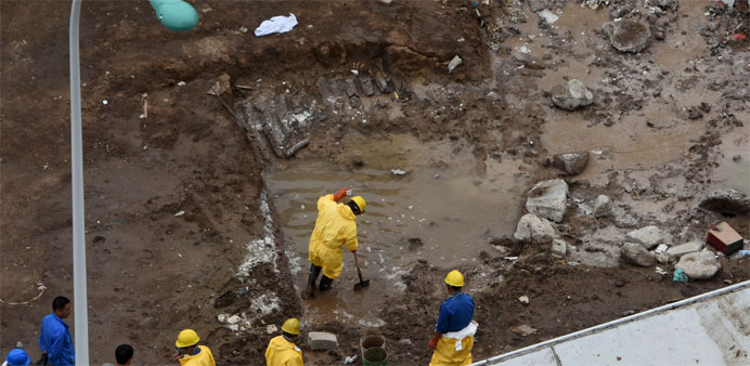 Rescue workers remove water polluted by chemicals from the site of explosions