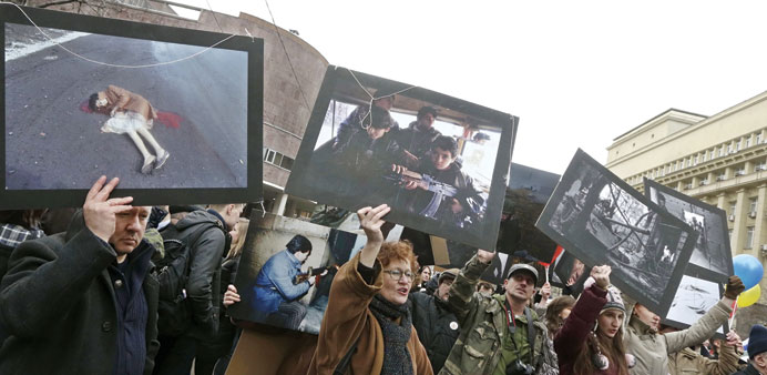 Protesters hold photos taken at different wars, during an anti-war rally against the Russian military actions in Ukraine, during the demonstration yes