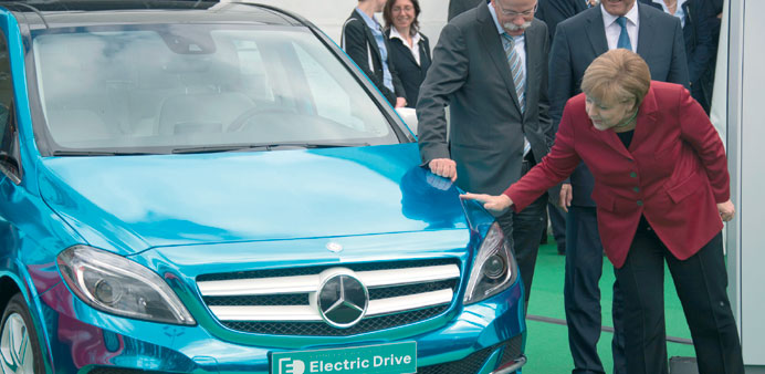    Merkel takes a close look and touches a Mercedes E-drive electric car as Daimler CEO Dieter Zetsche (to her right) looks on at the Electric Mobilit