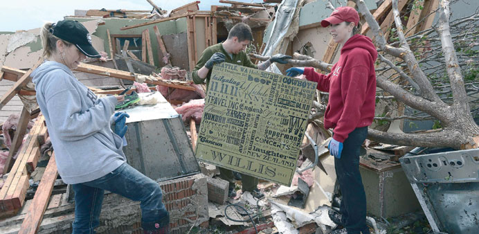People search through the rubble of a home in Moore, Oklahoma, yesterday.