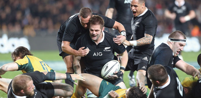 All Blacks Richie McCaw (C) celebrates his try with Aaron Cruden (L) and Aaron Smith (R) during their rugby union Test against Australian Wallabies at