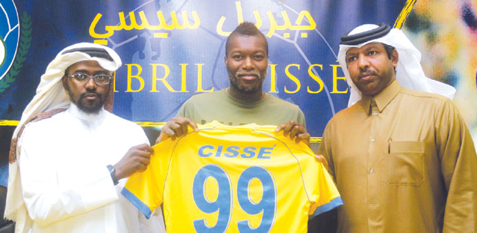 French striker Djibril Cisse (C) poses with Taha Ahazzai (R), media officer for Qataru2019s soccer team Al Gharafa, and Saud Fateh, team manager of Al Gha