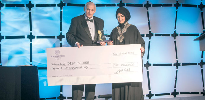 Best Picture winner Suleima Alhaj Abed, receives the award from  NU-Q Dean and CEO Everette Dennis.