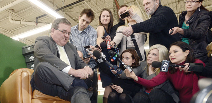 Flaherty is seen putting on a pair of pre-budget shoes at the Roots Leather Factory in Toronto in this file photo taken on March 20, 2013. Flaherty pa