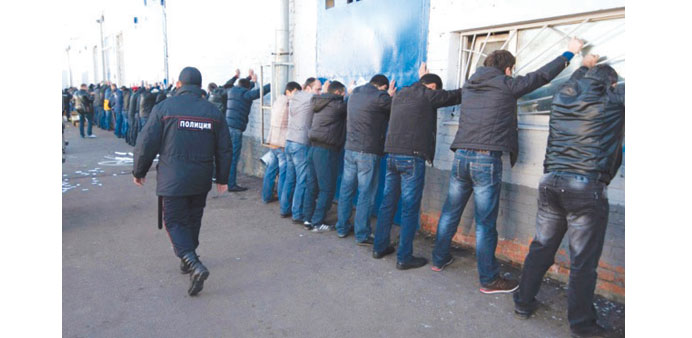 Russian police detain migrant workers during a raid at a vegetable warehouse complex.