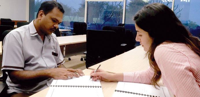 A Vodafone staff member giving English language class to a migrant worker.