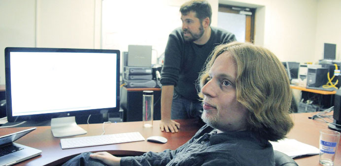 Assistant research professor Matthew Green standing behind graduate student Ian Myers, explaining how they want to tweak Zerocoin at Johns Hopkins Uni