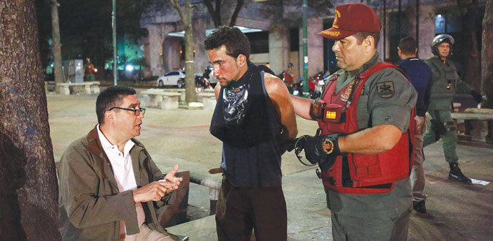 Venezuela Interior and Justice Minister Miguel Rodriguez Torres (left) speaks with an anti-government activist during operations at Altamira square in