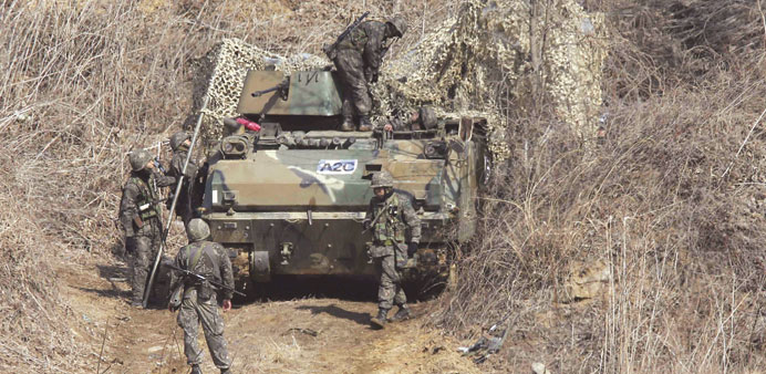 South Korean army soldiers disguise their armoured vehicle during a military exercise yesterday in Paju, near the demilitarised zone separating the tw