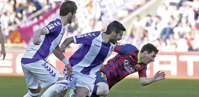 Valladolid midfielder Lluis Sastre (centre) vies with Barcelona forward Lionel Messi during their Spanish League clash yesterday. (AFP)