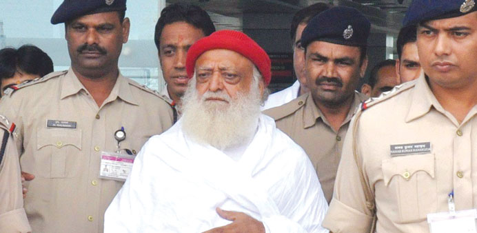 Asaram Bapu is escorted by police as he arrives at the Bhopal airport yesterday.