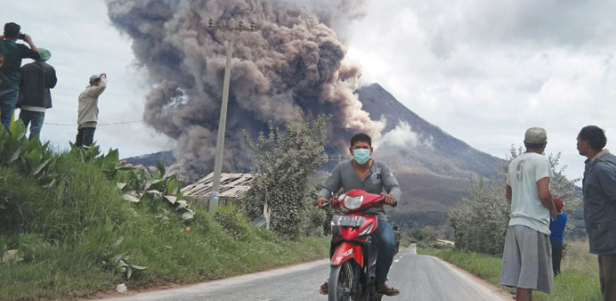 A resident rides his motorcycle as Mount Sinabung spews ash at Namanteran village in Karo Regency, Indonesiau2019s North Sumatra province yesterday.