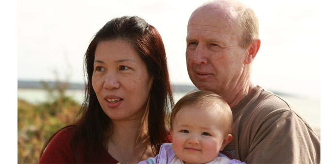 David Farnell, 56, and his wife Wendy (L), holding their daughter in Bunbury