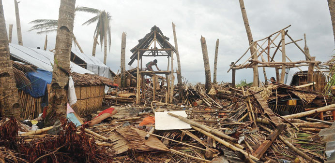 A man rebuilds his damaged house in Basay, Samar province.