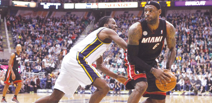 Miami Heat forward LeBron James (6) is defended by Utah Jazz forward DeMarre Carroll (3) during the first half of their NBA game in Salt Lake City, Ut