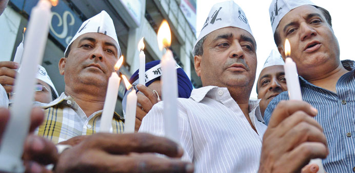 Members of the Aam Admi Party (AAP) hold candles as they demonstrate for the early release of 40 Indian workers abducted in Iraq, in Amritsar yesterda