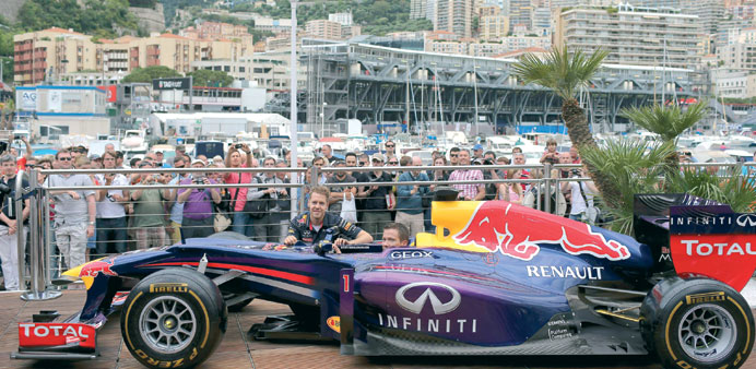 Red Bull driver Sebastian Vettel (left) poses with Volkswagen French rally driver Sebastien Ogier during a promotional event at the Monte Carlo circui