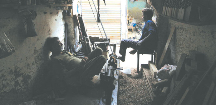 Carpenters at a workshop pause during a power outage in a Karachi.