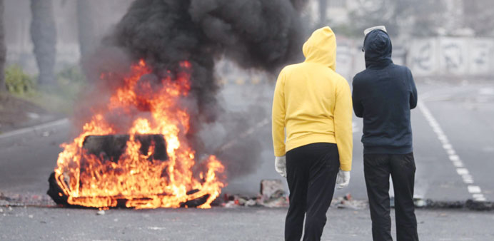 Demonstrators standing near a burning garbage container in the village of Sanabis, west of Manama, yesterday.
