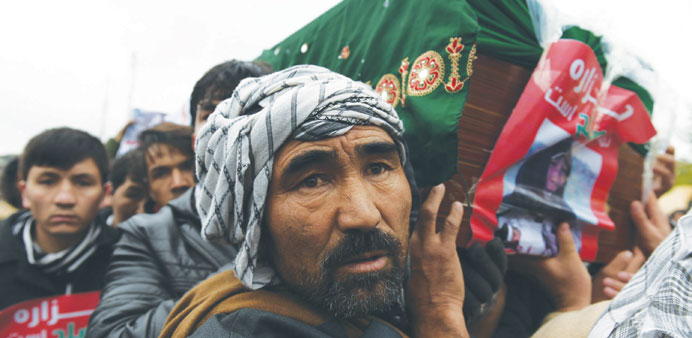 Afghan protesters carry a coffin containing a decapitated body of one of seven Shia Hazaras, including four men, two women and one child, during a dem