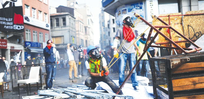  A protester prepares to launch a projectile at riot police.