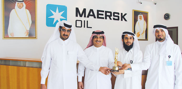 Maersk Oil officials show off the award trophy.