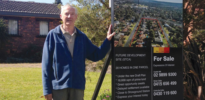 Ron Buxton poses with his homeu2019s for-sale sign in the suburb of Castle Hill, Sydney.