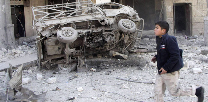 A boy runs past a damaged van after what activists said was an air raid by regime forces in Aleppou2019s Marjeh district yesterday.
