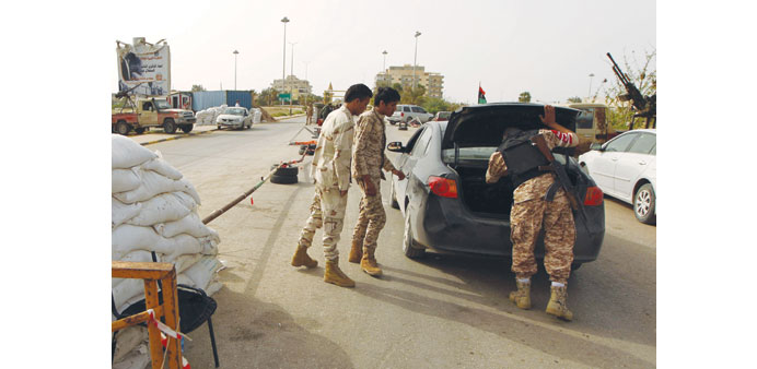  Soldiers inspect a car at a checkpoint in Benghaziu2019s northern district of Sabri yesterday, the day after a suicide car bomb attack on an army checkpo